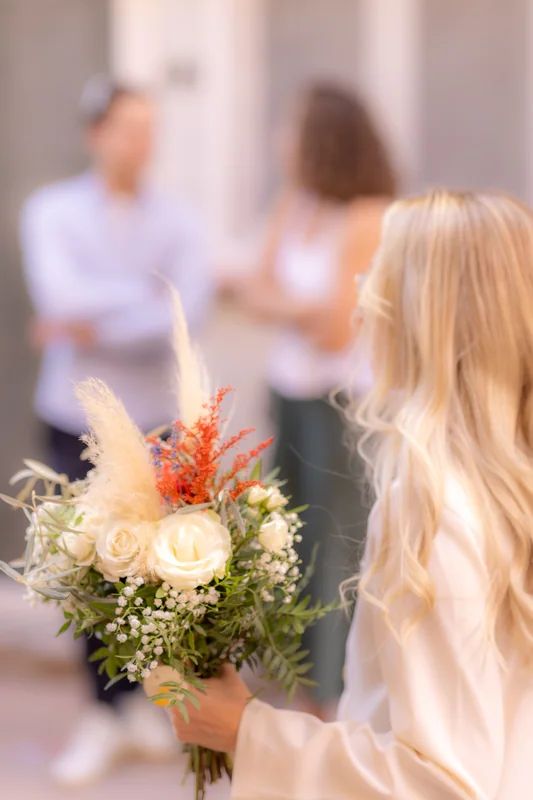 Un bouquet au premier plan, avec les invités en arrière-plan.