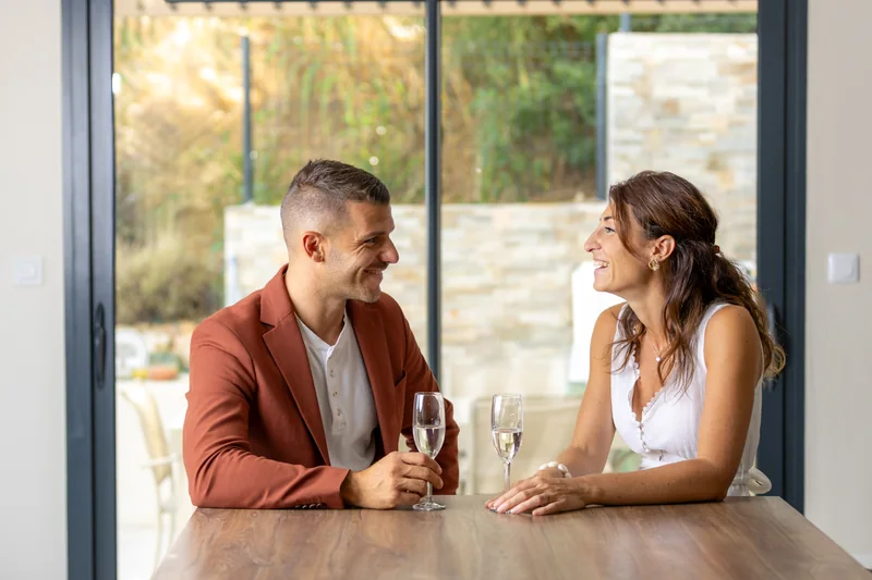 Un couple échange un regard autour d’une table.